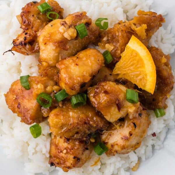 An orange chicken dish served on a white plate.