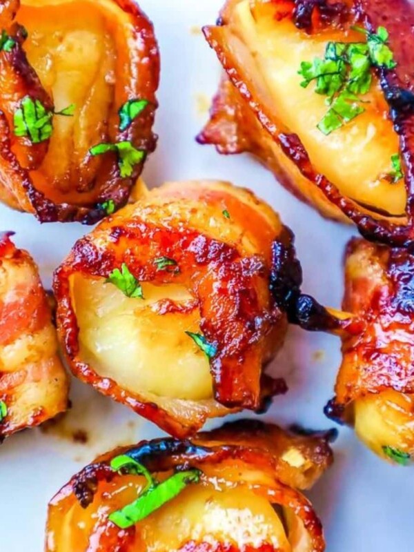 picture of bacon wrapped scallops with a brown sugar glaze topped with chopped parsley