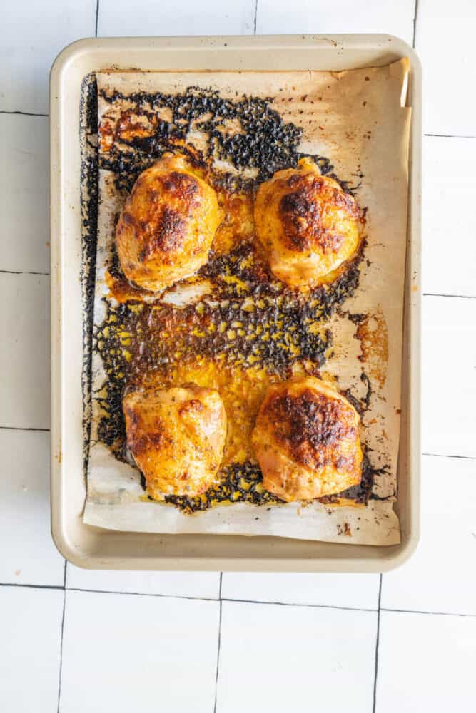 Roasted chicken breasts on a baking sheet with ranch seasoning.