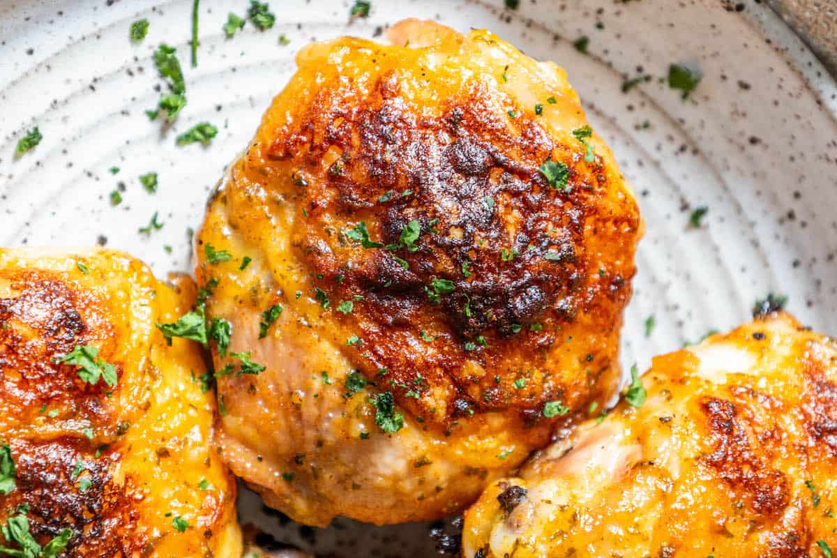 Grilled chicken breasts on a plate with parsley, baked ranch chicken.