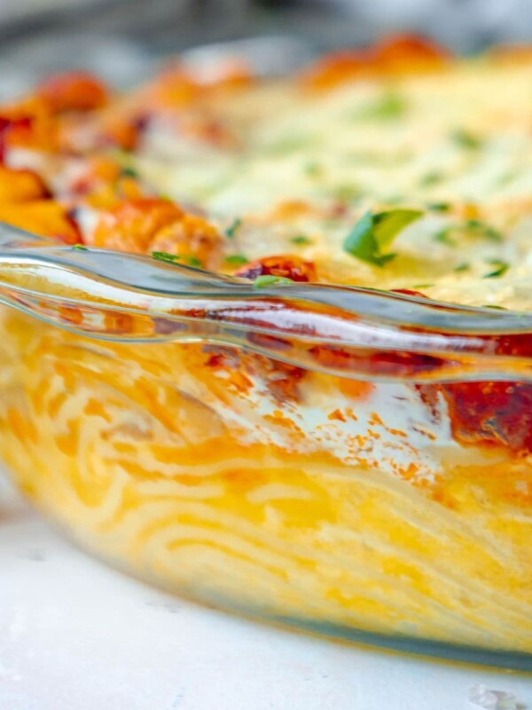 picture of baked spaghetti pie in a glass dish topped with cheese on a table