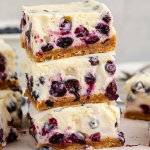 blueberry cheesecake bars stacked on top of each other on a table