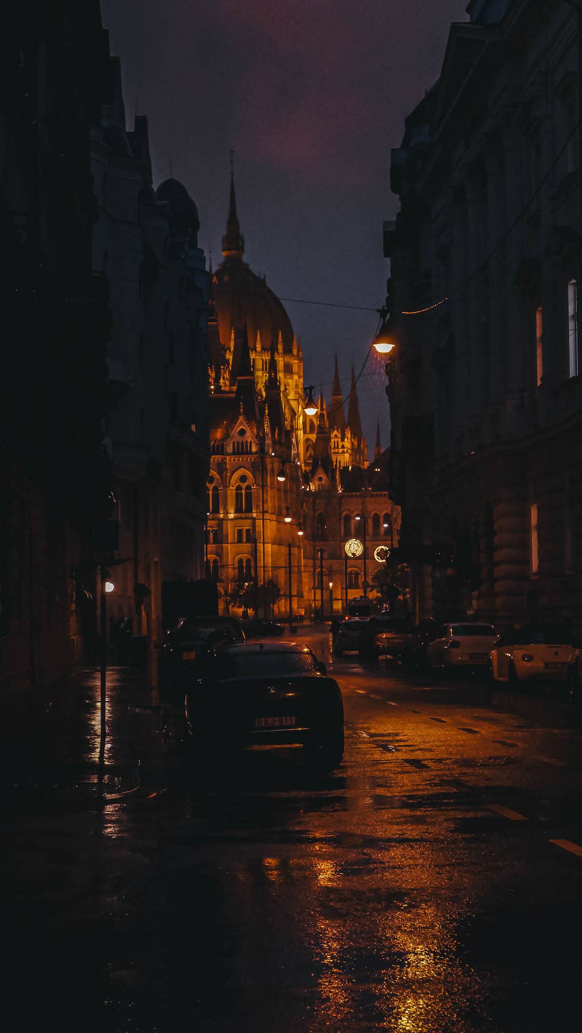 A car is parked in front of a building at night.