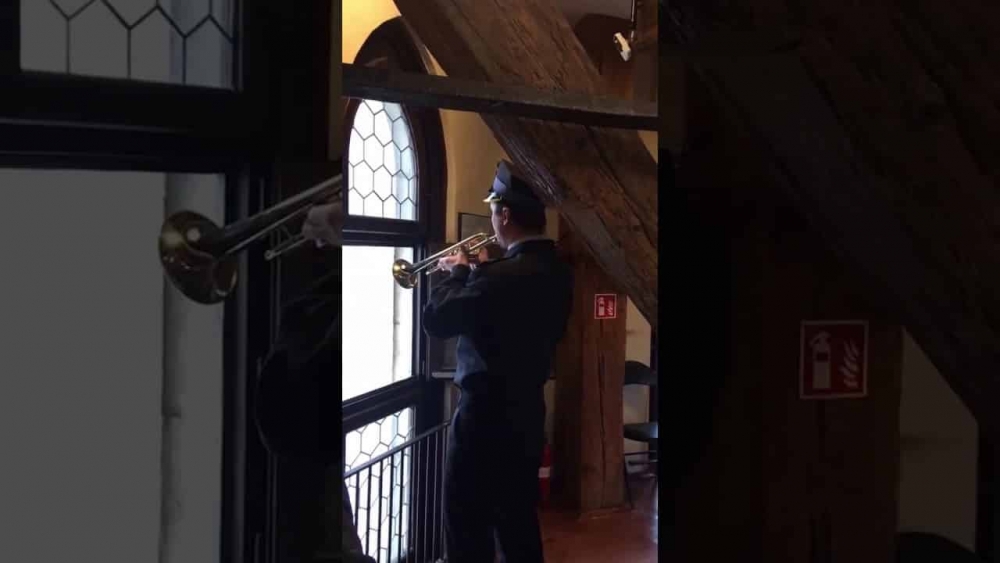 A man in a suit playing a trumpet in Saint Mary's Basilica Krakow.