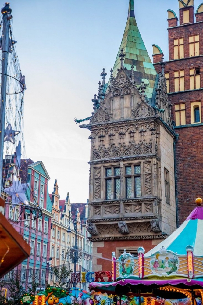 A Wroclaw Christmas market with buildings in the background.