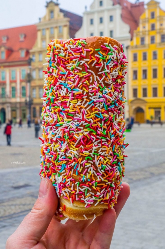 A person enjoying a festive donut at the Wroclaw Christmas Market.