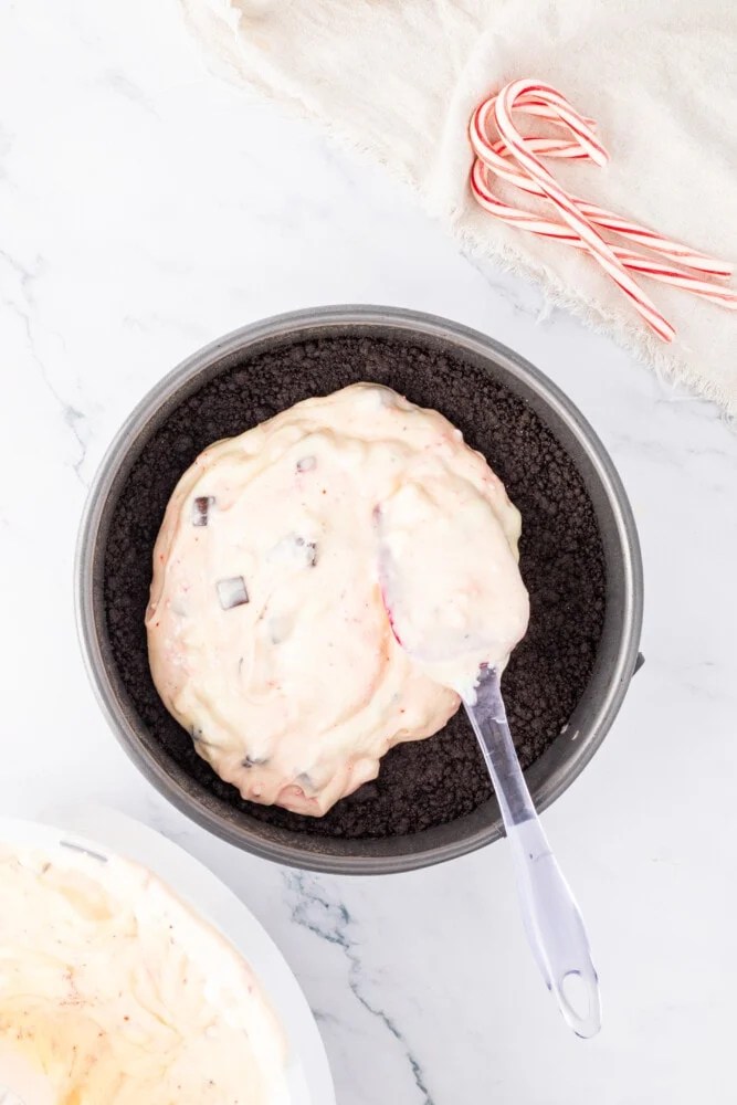 A bowl of candy cane pie with a spoon next to it.