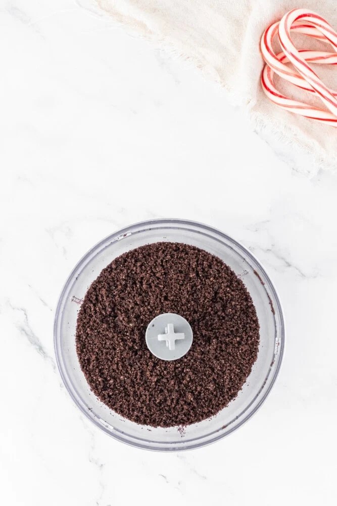 A food processor filled with chocolate powder and candy canes.