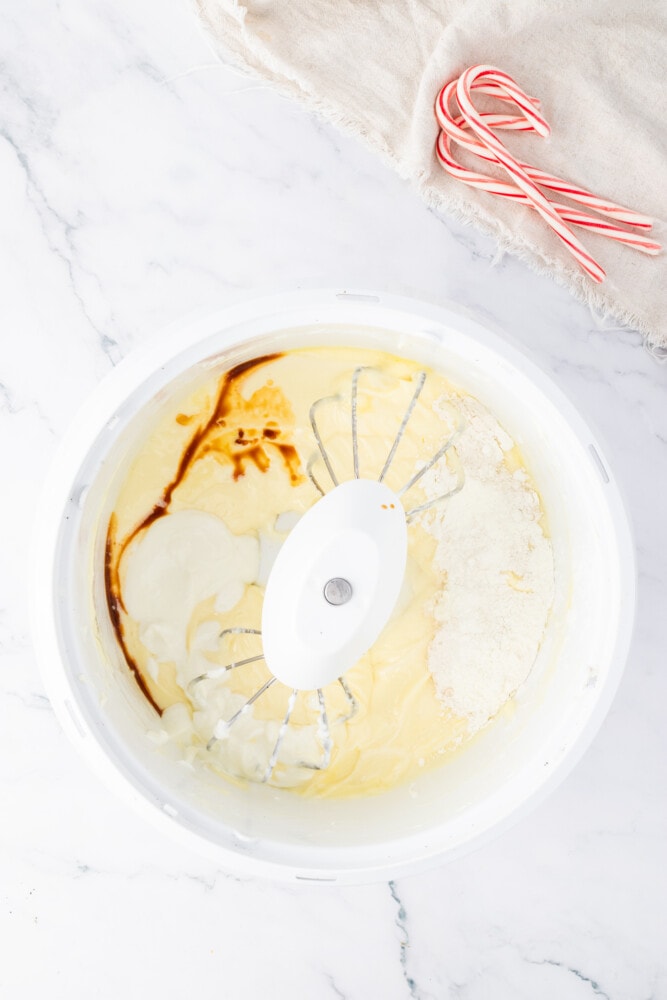 A white bowl with whipped cream and candy canes.