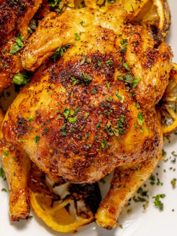 air fried cornish game hens seasoned with herbs and topped with chopped parsley on a white plate