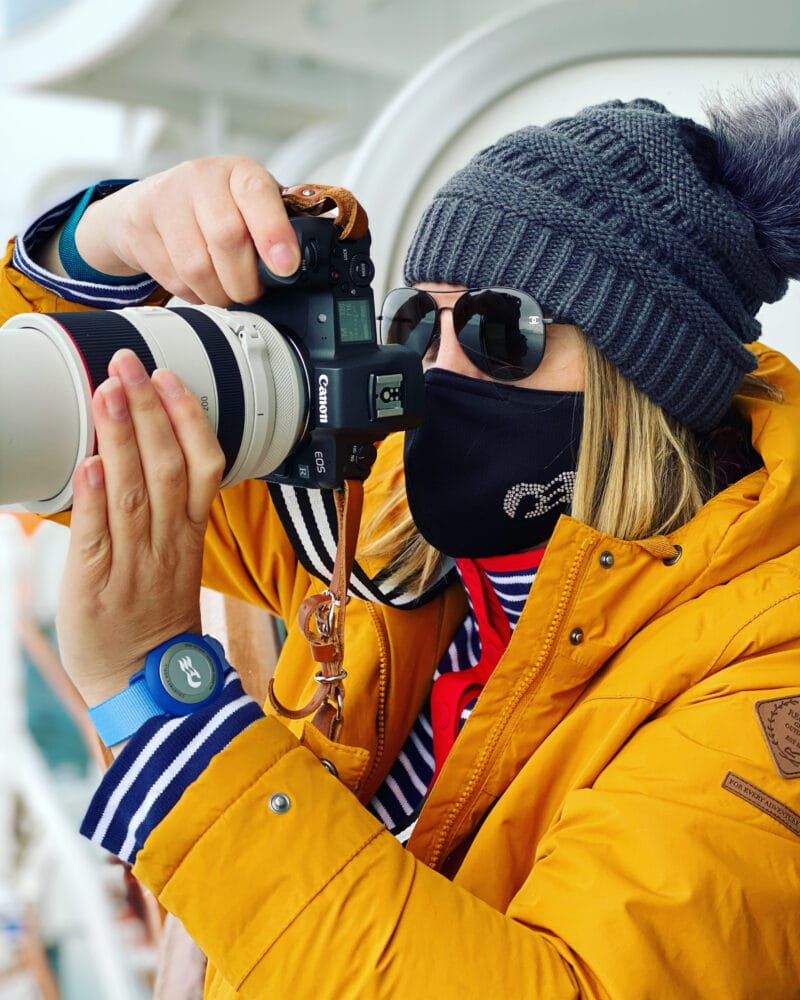 picture of a woman in a yellow jacket with a princess cruise facemask and oceanmedallion