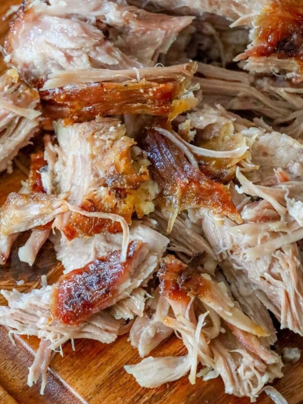 shredded pork shoulder with crispy skin on a cutting board