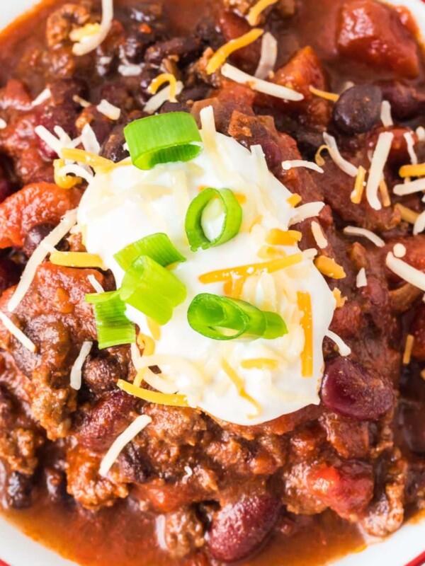 picture of chili in a bowl with sour cream, green onions, and cheese on top