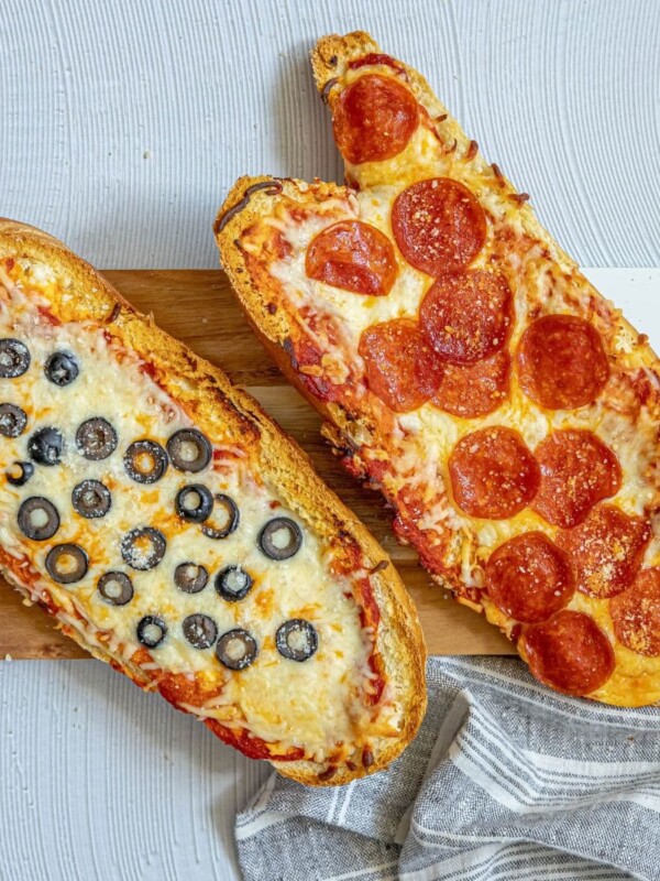 picture of pizza baked on loaves of french bread on a cutting board