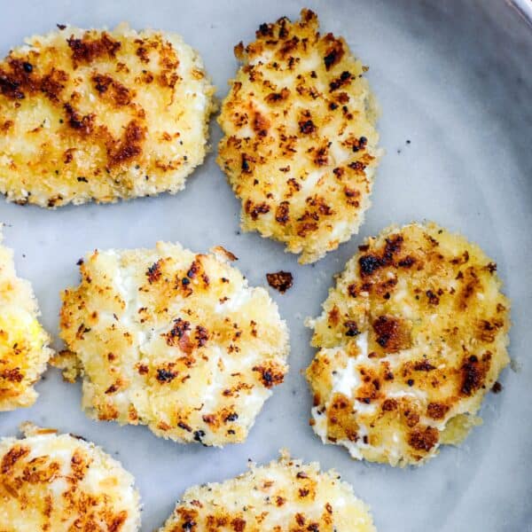 Golden brown, breaded cauliflower steaks on a gray plate.