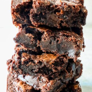 super chocolatey fudge brownies stacked on top of each other on a table