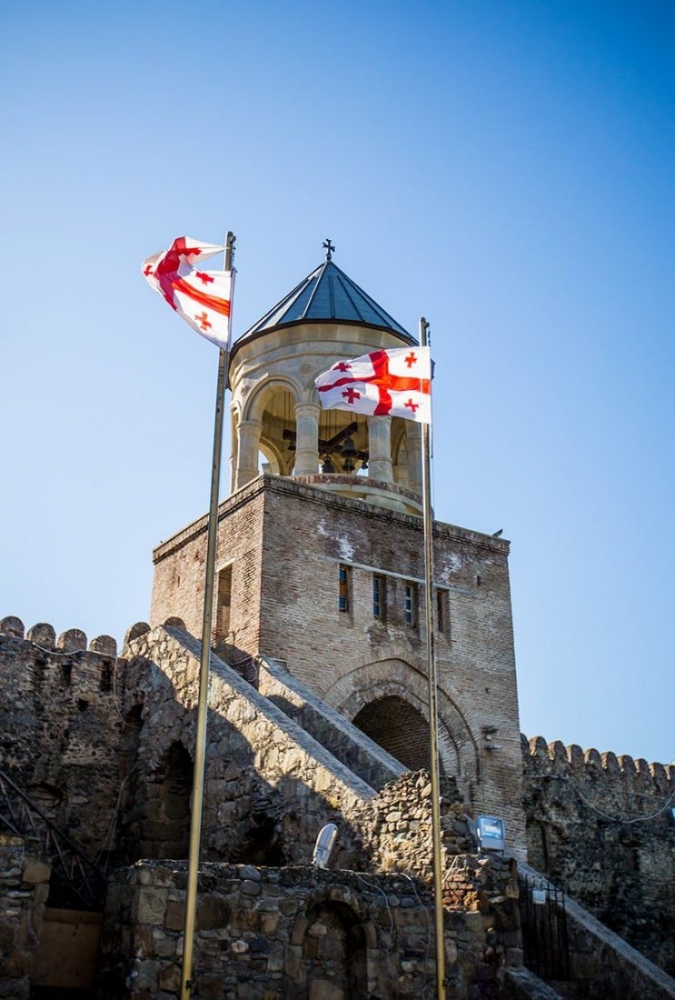 picture of cathedral and Georgian flag in Tbilisi, Georgia