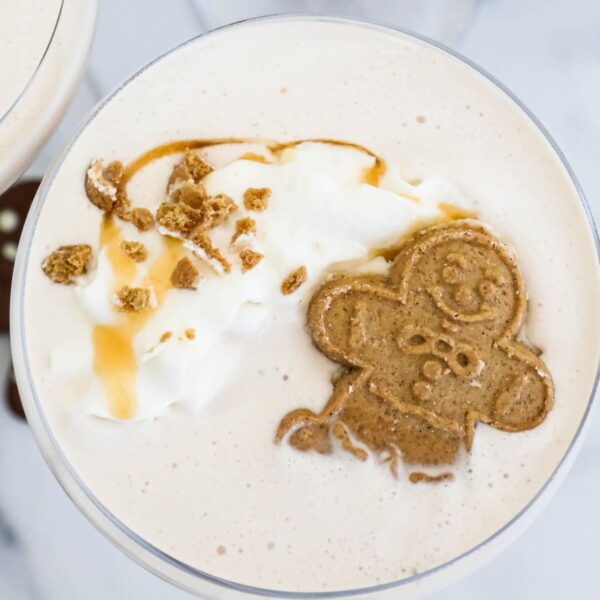 A gingerbread latte with whipped cream and a gingerbread man.