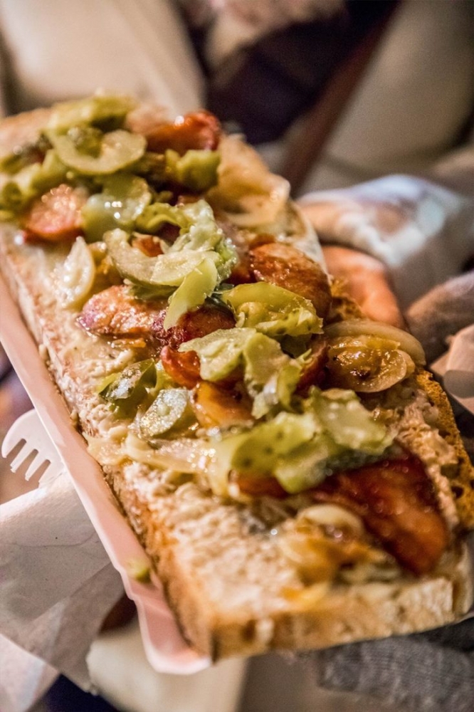 A person is holding a large pizza at Wroclaw Christmas Market.