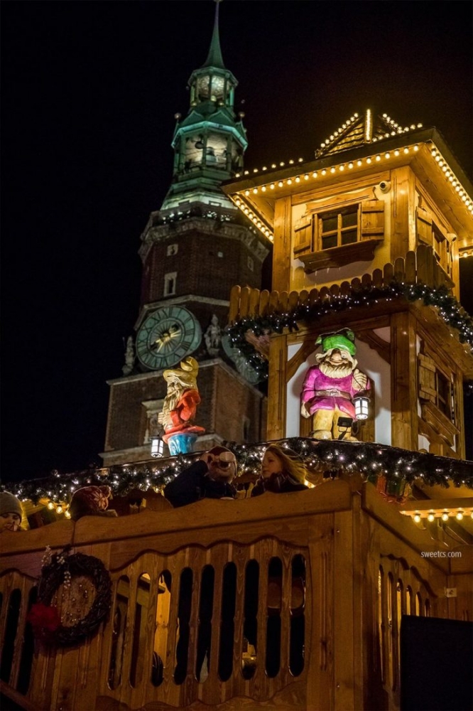 A Wroclaw Christmas market showcasing a clock tower in the background.