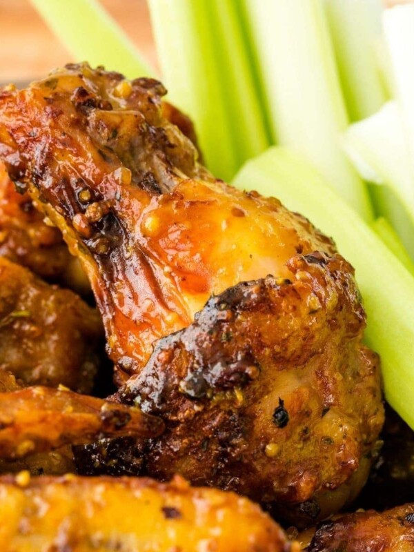 Chicken wings with honey mustard sauce served alongside celery sticks.