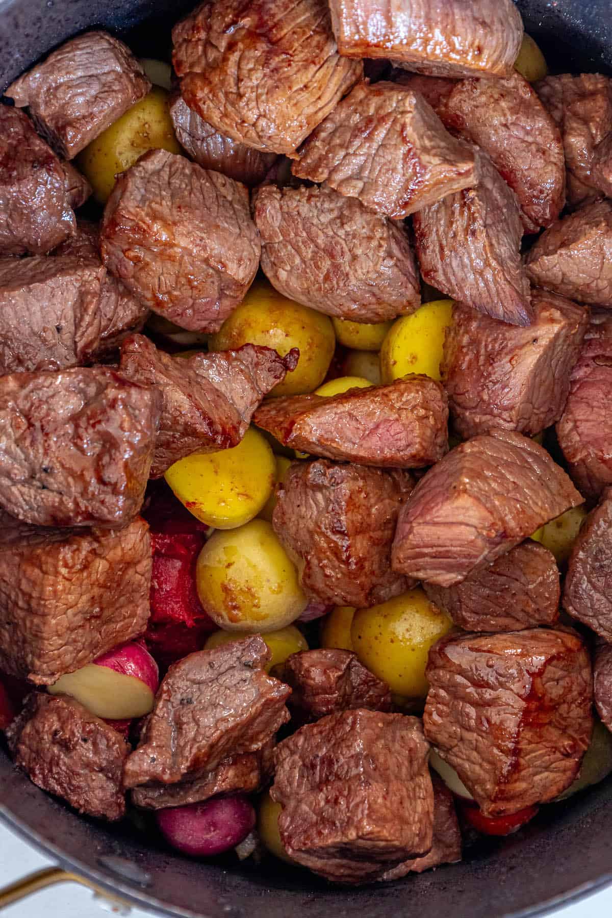 The Best Goulash recipe made with goulash beef stew cooked in a skillet, served with potatoes.