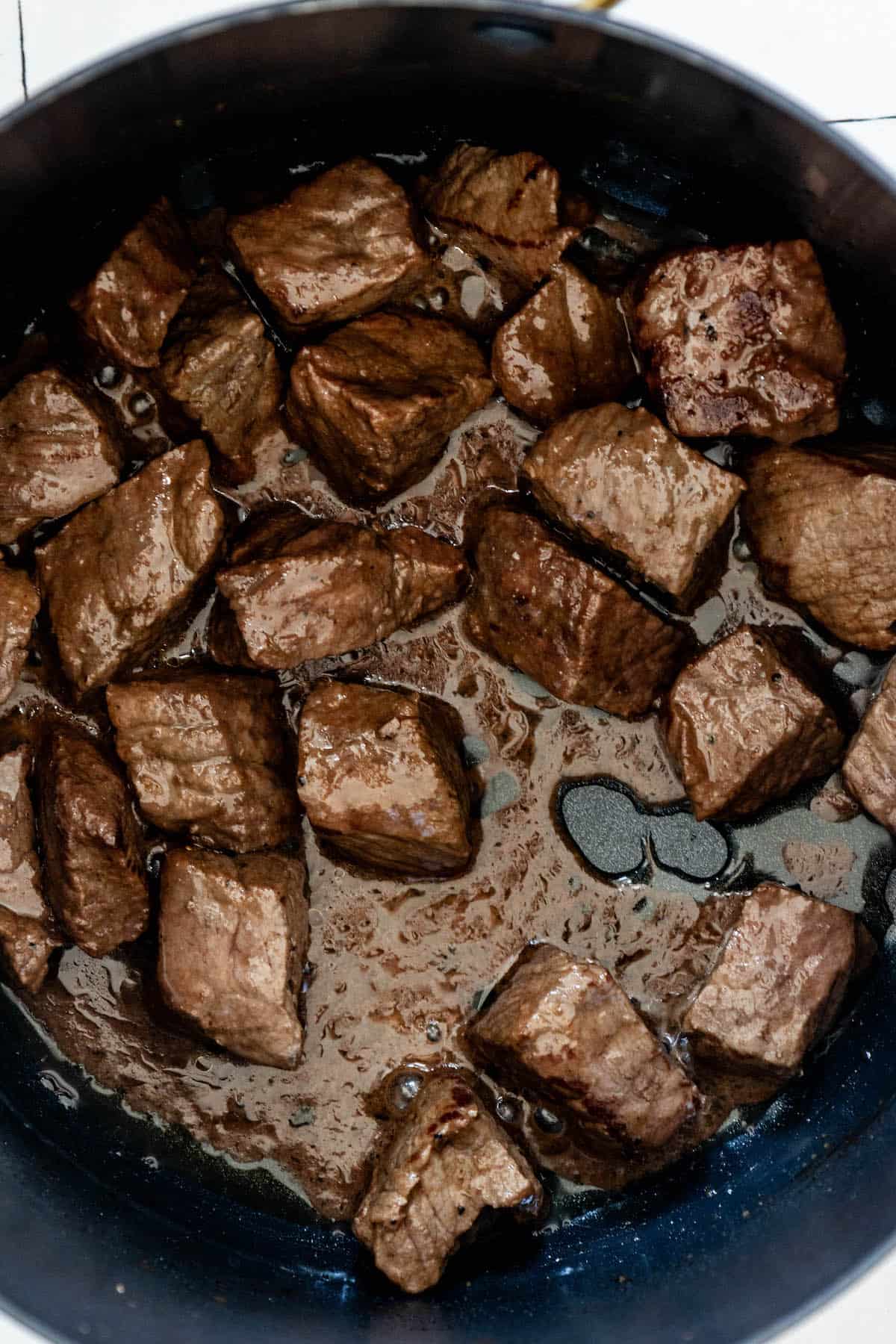 A keto-friendly frying pan with beef cubes simmering in an easy one-pot authentic Hungarian goulash stew.