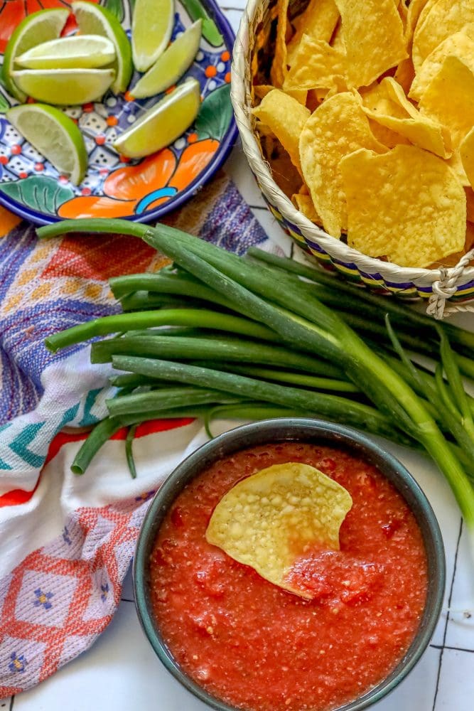 picture of a chip in a bowl of salsa on a table