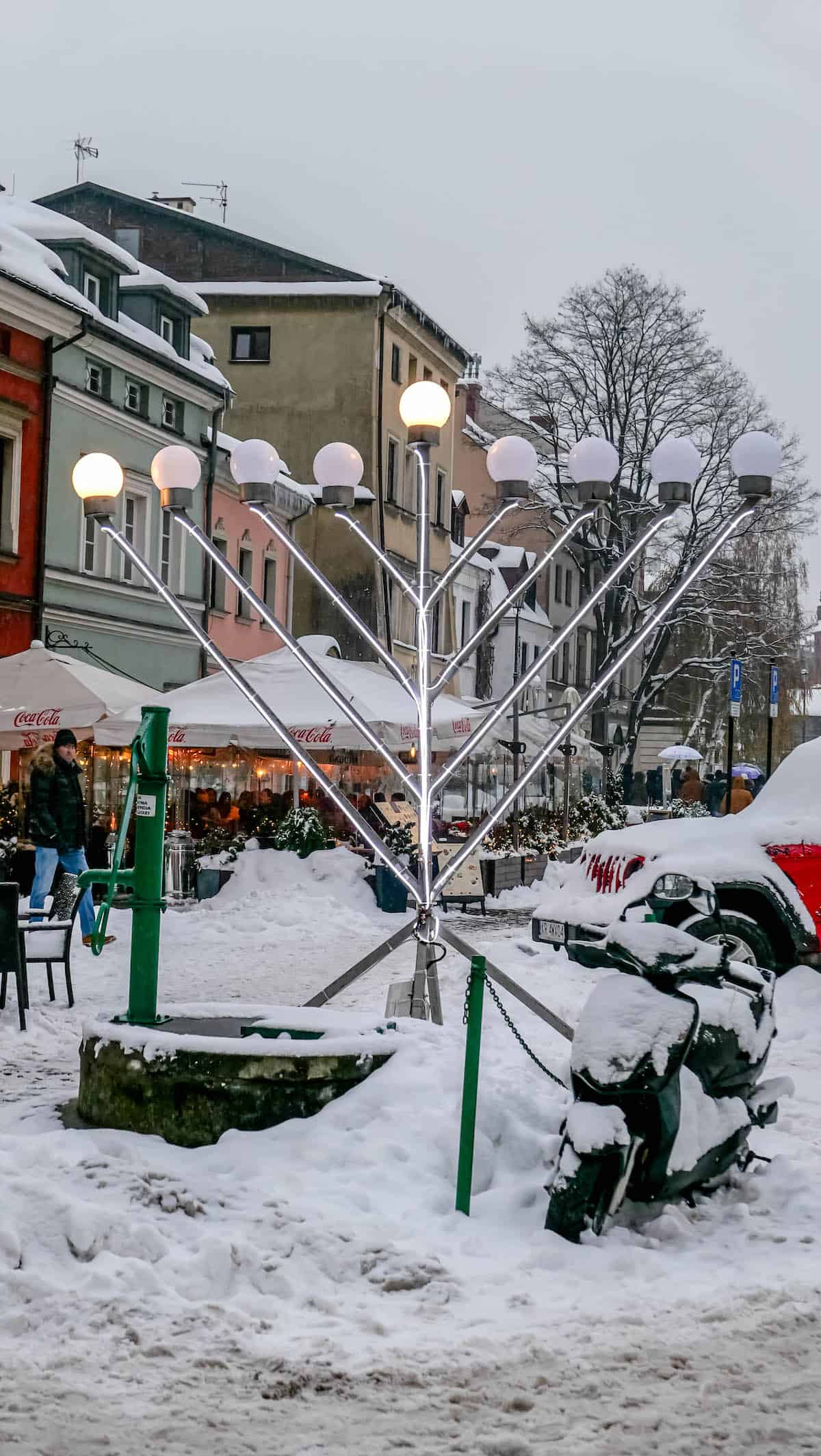 A Polish menorah in the middle of a snow covered street.