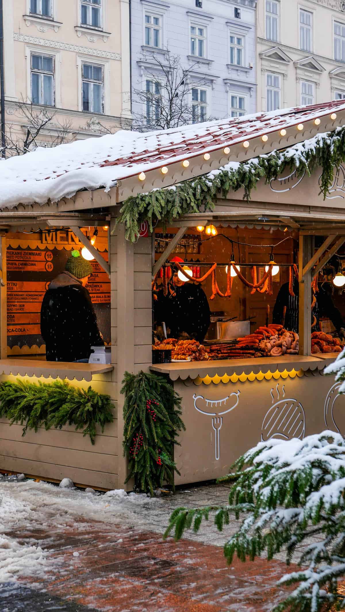 A tan building with snow on it, reminiscent of a country style village in Poland.