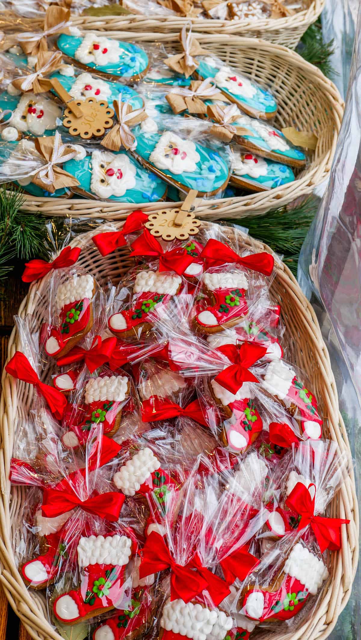 Baskets of decorated Christmas cookies, with some wrapped in clear plastic and adorned with red bows, evoke the festive spirit of the Krakow Christmas Market.