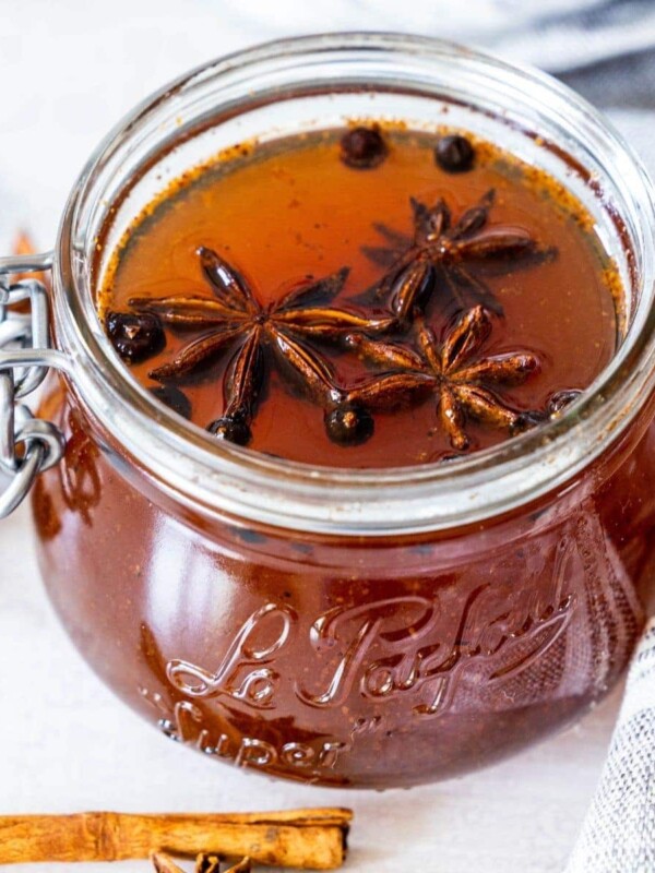 picture of mulled simple syrup in a jar with star anise and juniper berries floating on top