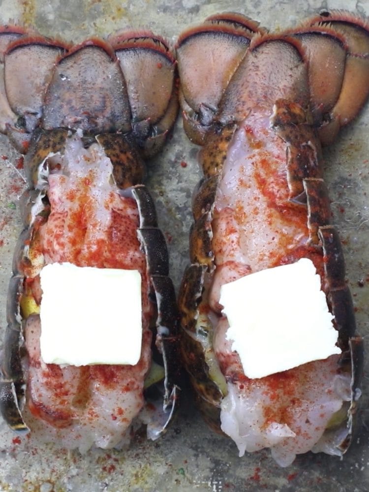 raw lobster tail with paprika and butter on top