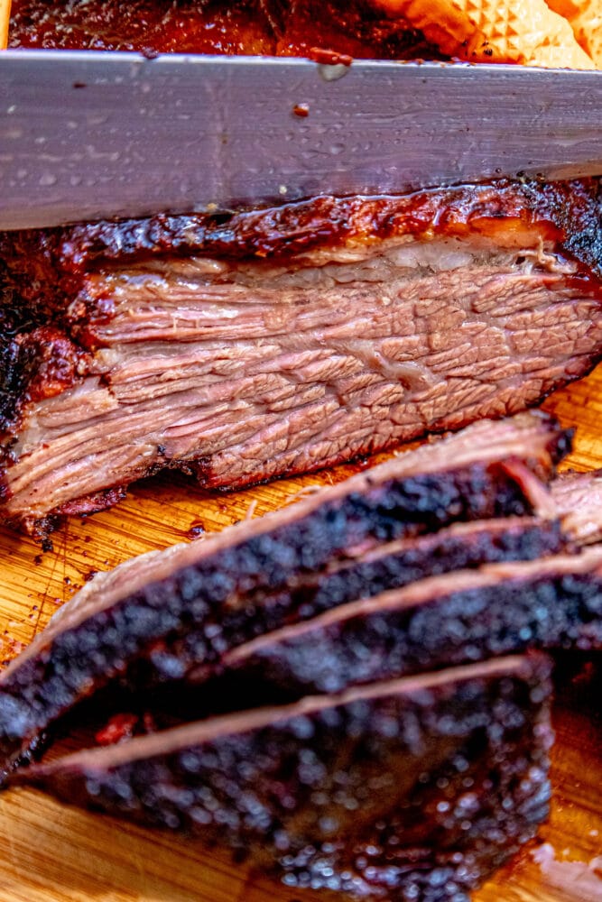 sliced smoked brisket on a wood cutting board