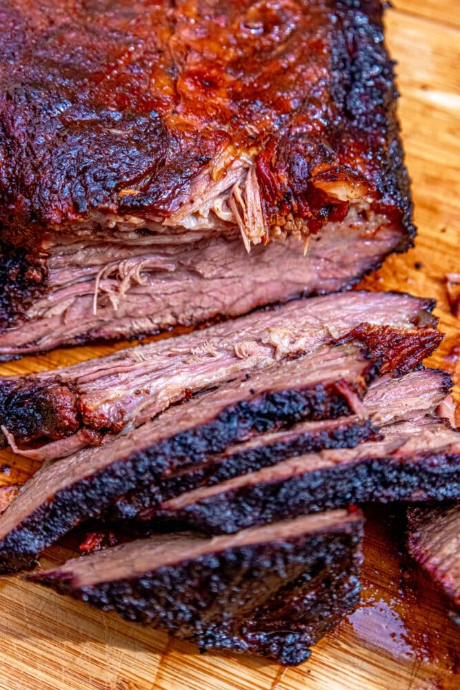 sliced smoked brisket on a wood cutting board