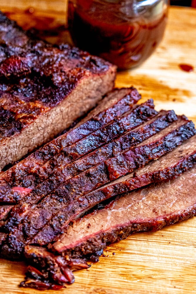 sliced smoked brisket on a wood cutting board