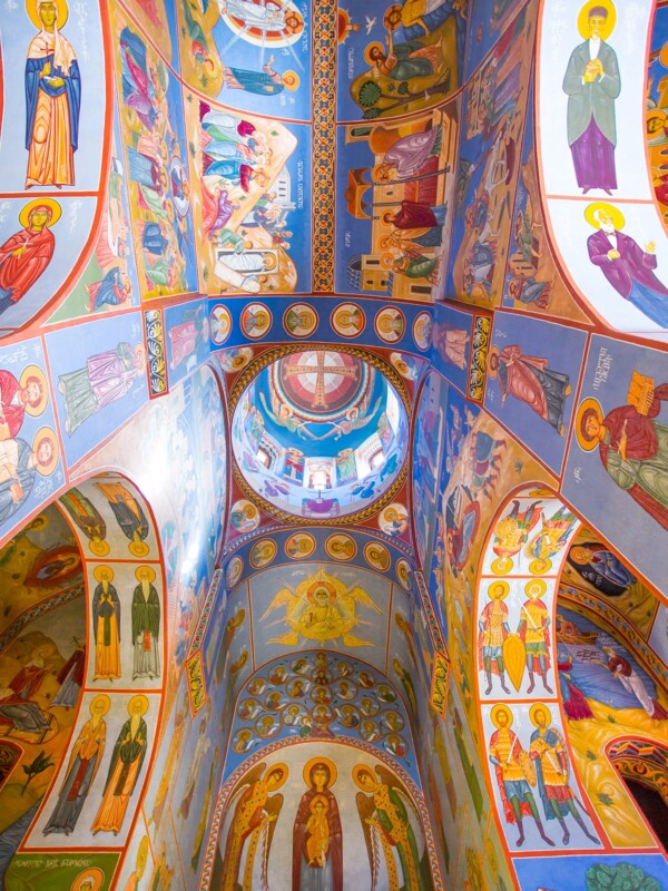 The interior of Lurji Monastery showcases colorful paintings on the ceiling.