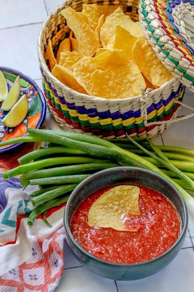 picture of a chip in a bowl of salsa on a table