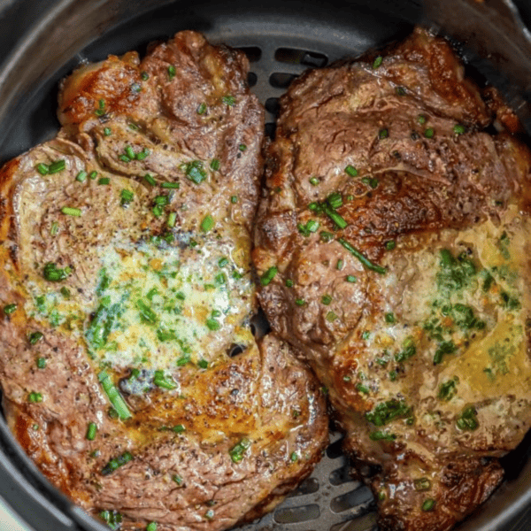 An Air Fryer Ribeye Steak cooking in a pot.