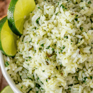 Close-up of a bowl of cilantro lime rice garnished with lime slices.